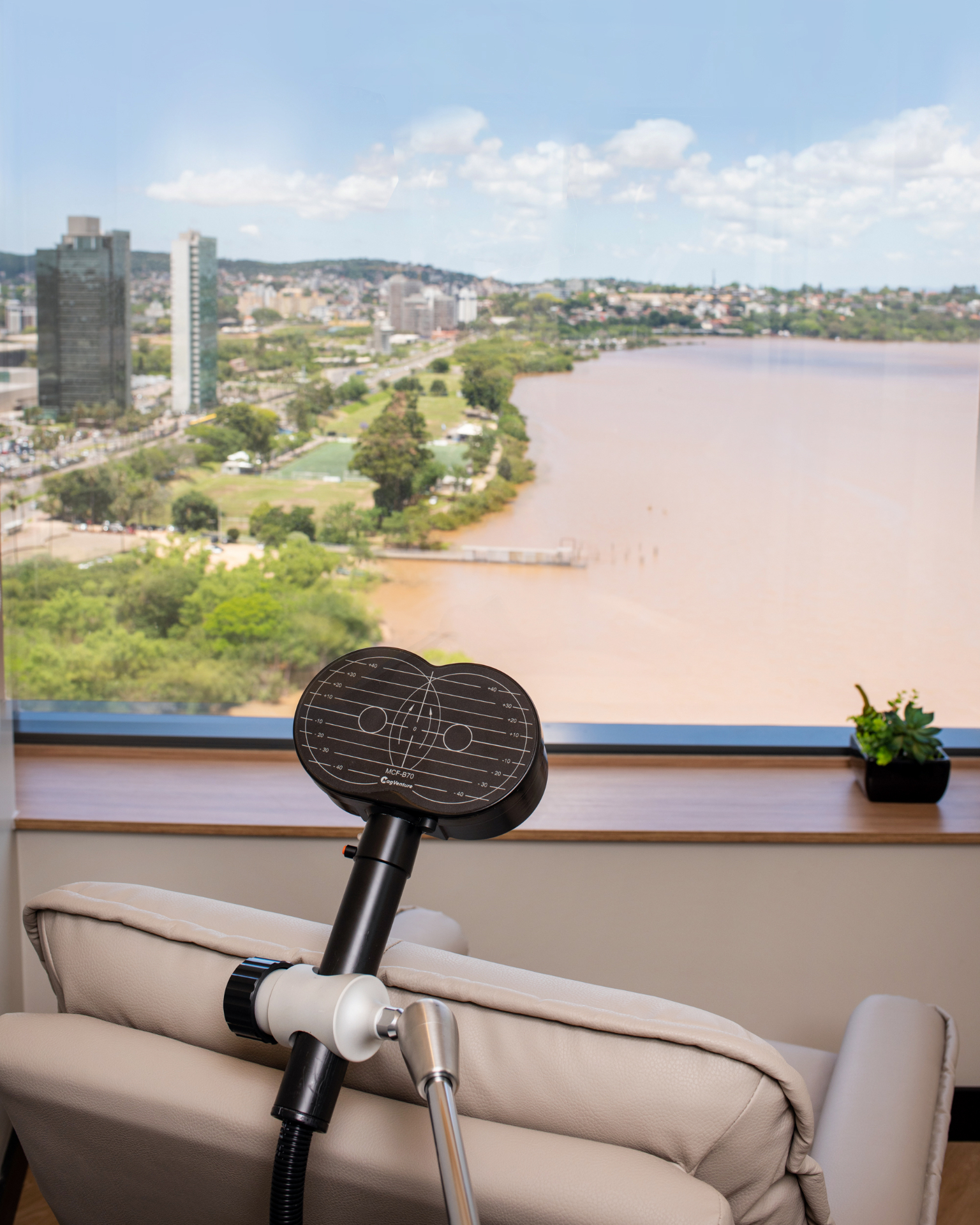 Sala de EMT da Clínica Sinapta com bobina de estimulação magnética e vista para Porto Alegre